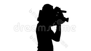 <strong>摄影</strong>师肩上扛着摄像机。 白色背景。 剪影。 侧视图
